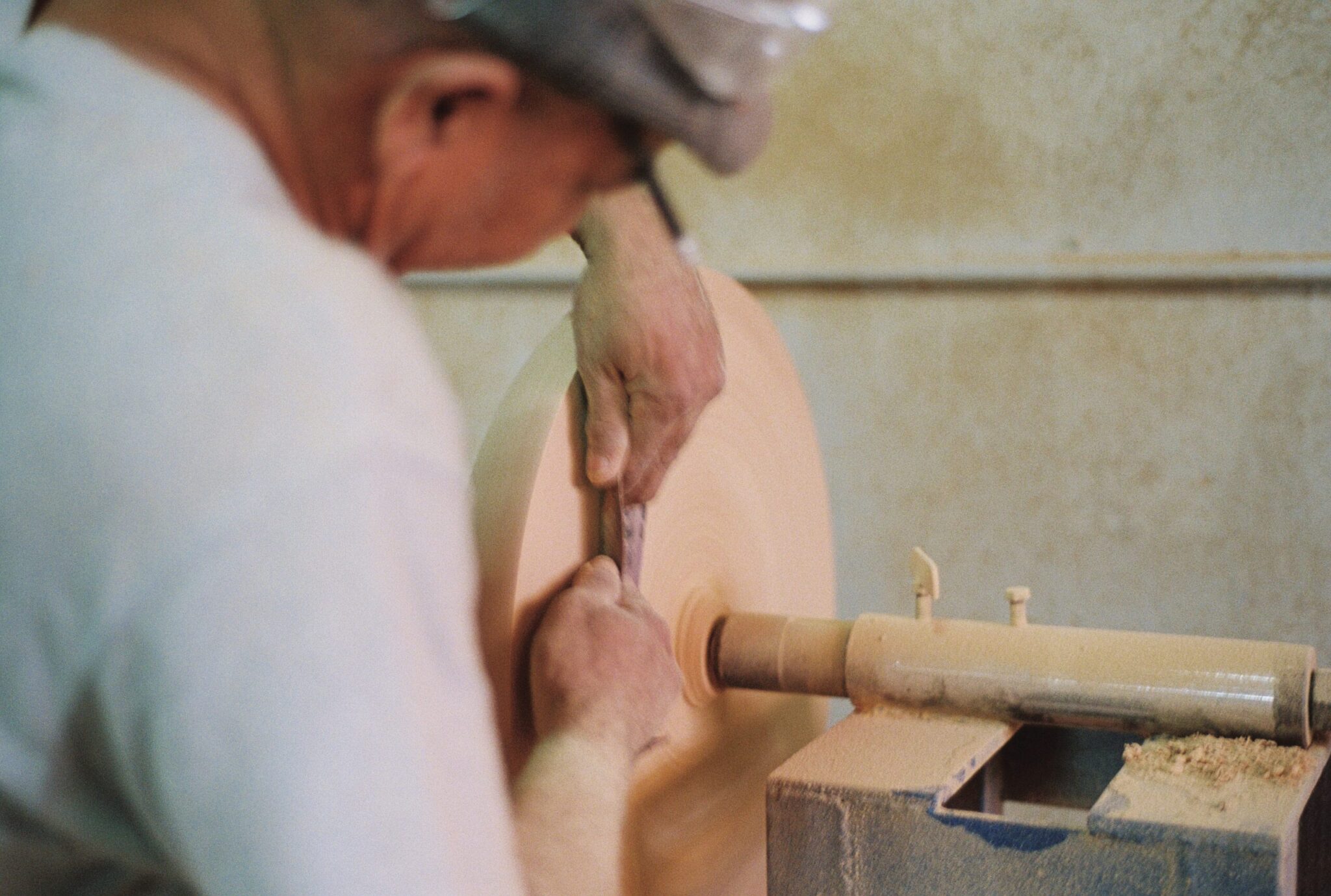 Furniture artisans mixing concrete and shaping wood components for designer furniture production.