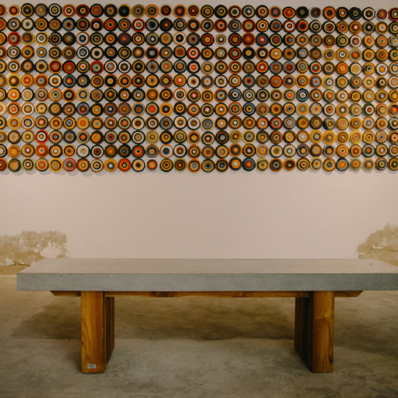Concrete bench with rectangular top and square teak wood legs by Gola Home, handcrafted in the Dominican Republic for modern indoor and outdoor spaces.