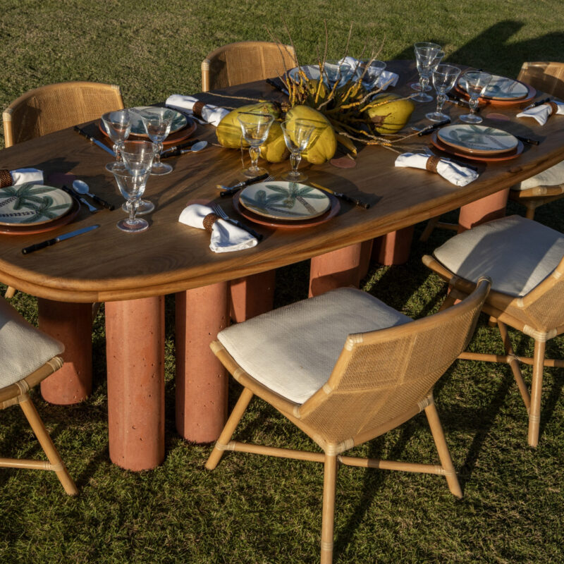 Pilares dining table with solid oak tabletop featuring terracotta concrete circular inlays aligned with eight supporting pillars, artisan Caribbean dining table for 6 to 8 people.