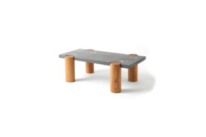 CACIQUE coffee table with a rectangular concrete top inlaid with white concrete and bronze elements, supported by four solid Caribbean hardwood pillars.