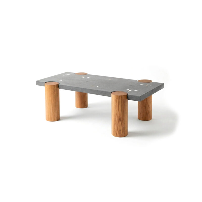 CACIQUE coffee table with a rectangular concrete top inlaid with white concrete and bronze elements, supported by four solid Caribbean hardwood pillars.