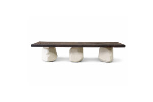 CAUTÚ coffee table with burnt wood top and bronze staples, supported by sculptural stone-like concrete bases, handcrafted by Gola Home in the Dominican Republic.