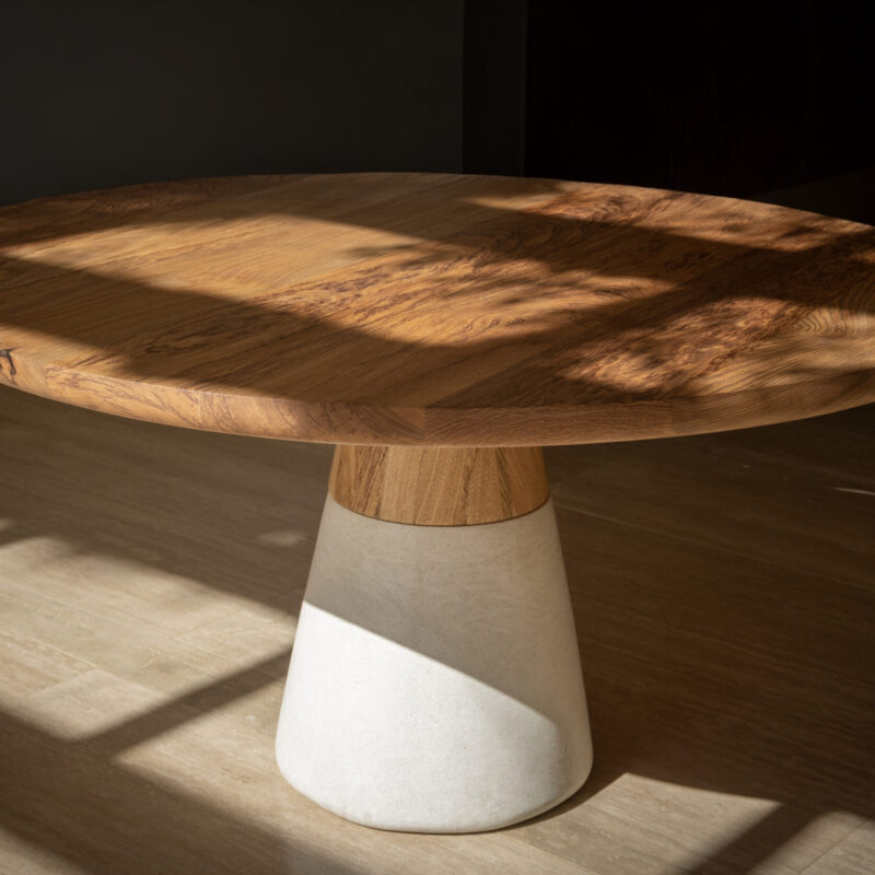 Bahia solid rosewood dining table with natural wood grain tabletop and sculptural white concrete and oak conical base.